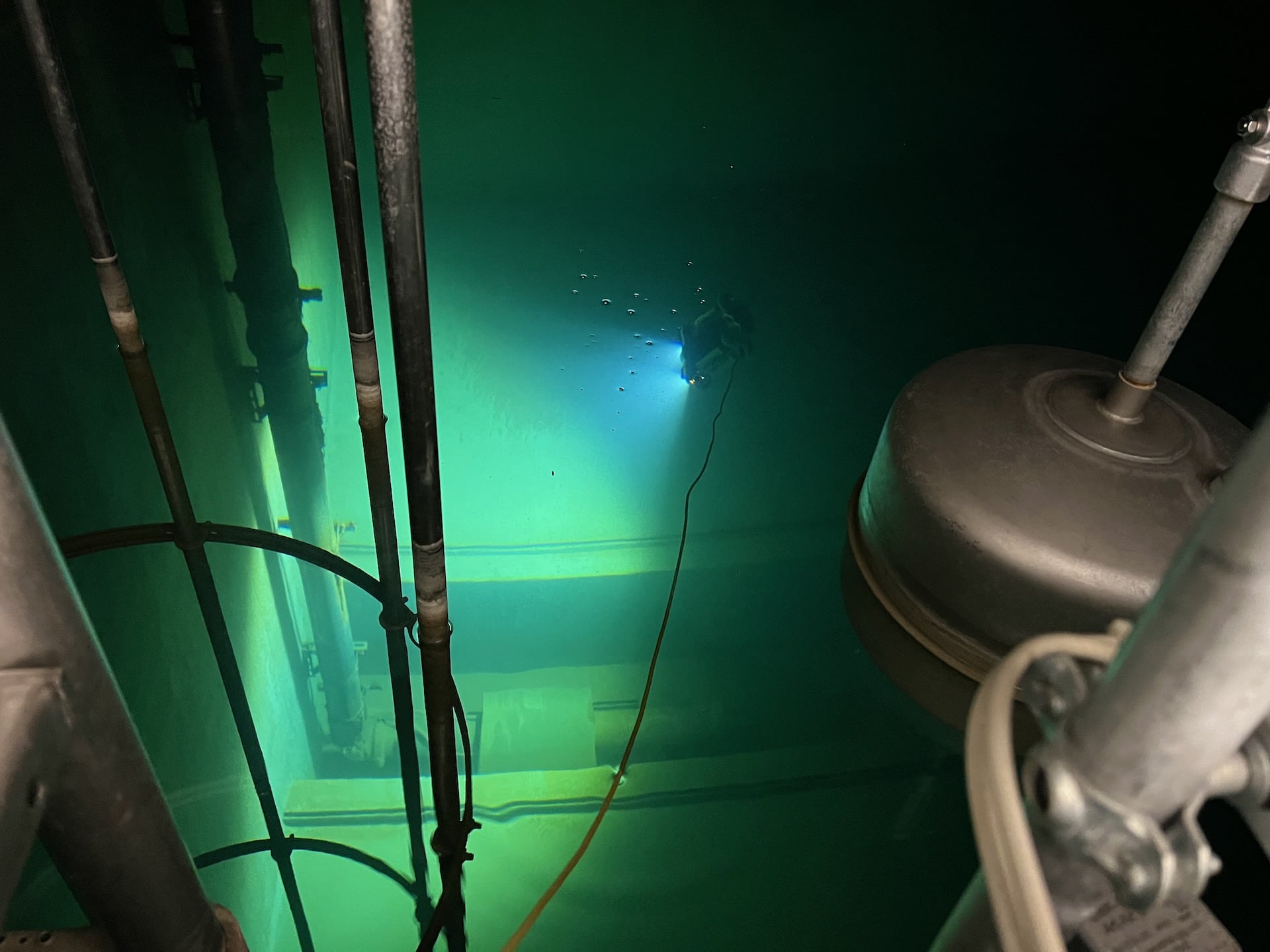 Underwater drone inspecting pump sump of sprinkler tank