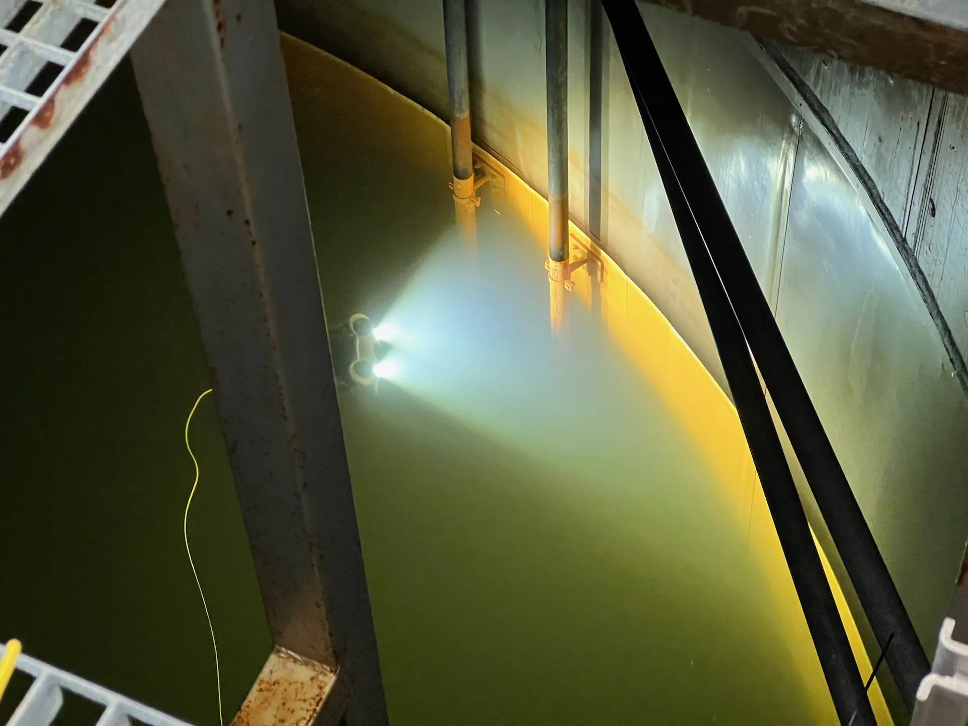 Underwater drone illuminating outer wall inside sprinkler tank